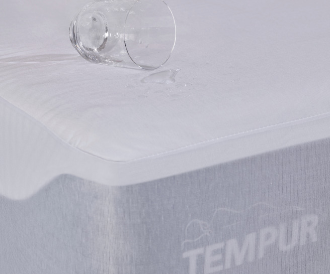 home-by-tempur_bed-corner-dark-zoom-w-glass-on-mattress-protector-logo-showing-angled-right_03-0152_1688372873-455cd5812574a34b8f41399efdf31a17.jpg